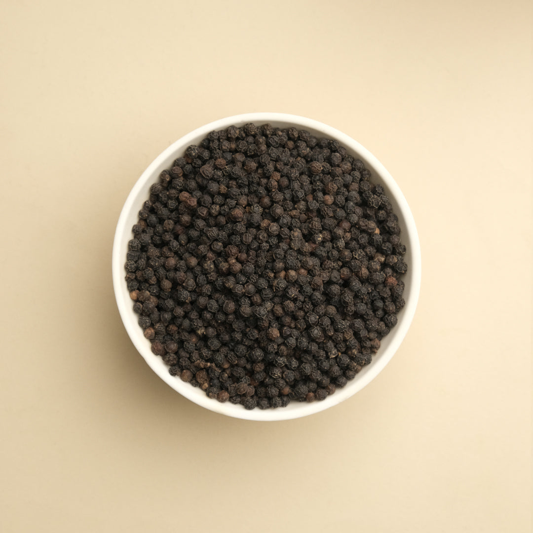 Close-up of whole black peppercorns showing quality and freshness, perfect for grinding